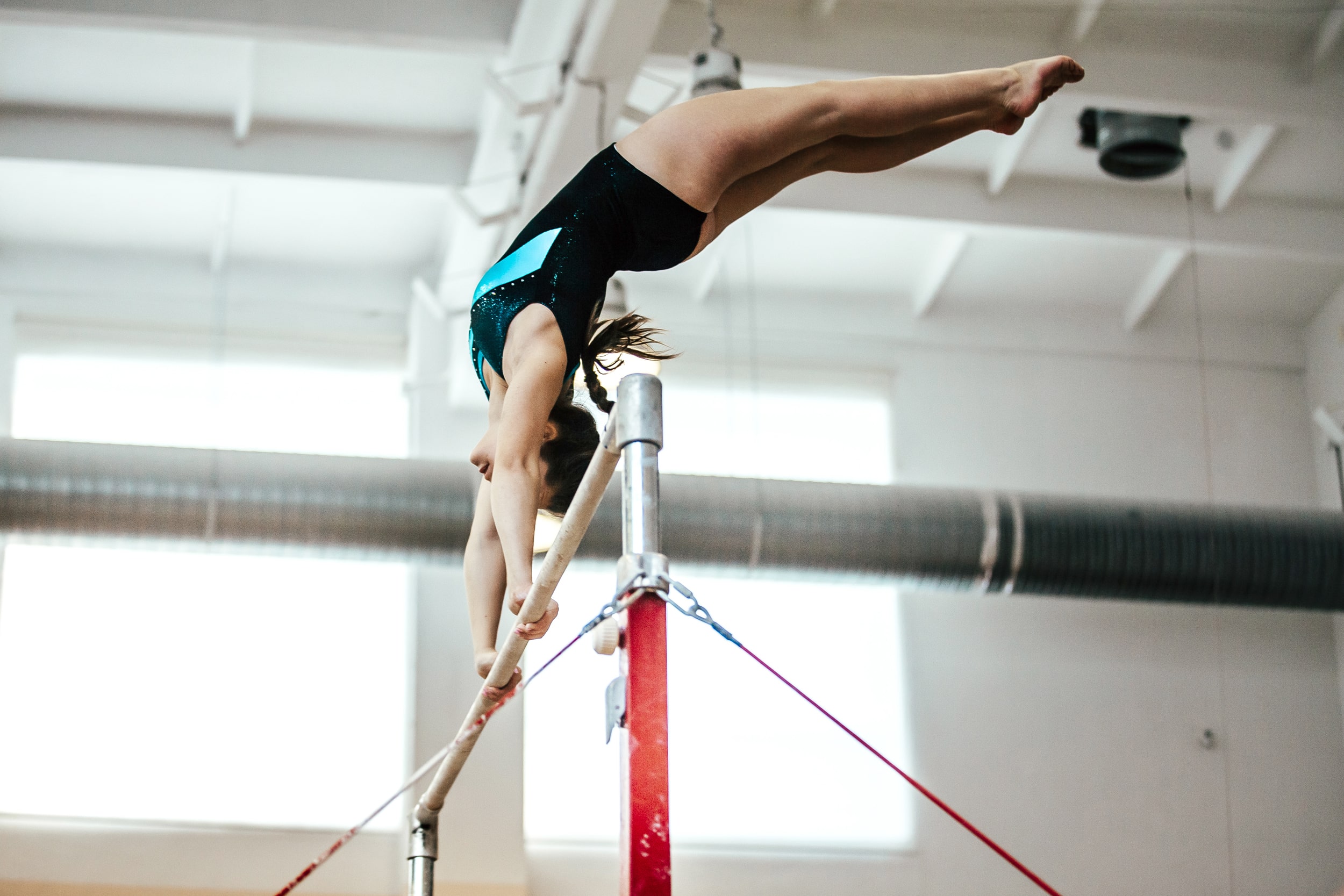 Girl using the high bar in a gymnastics gym