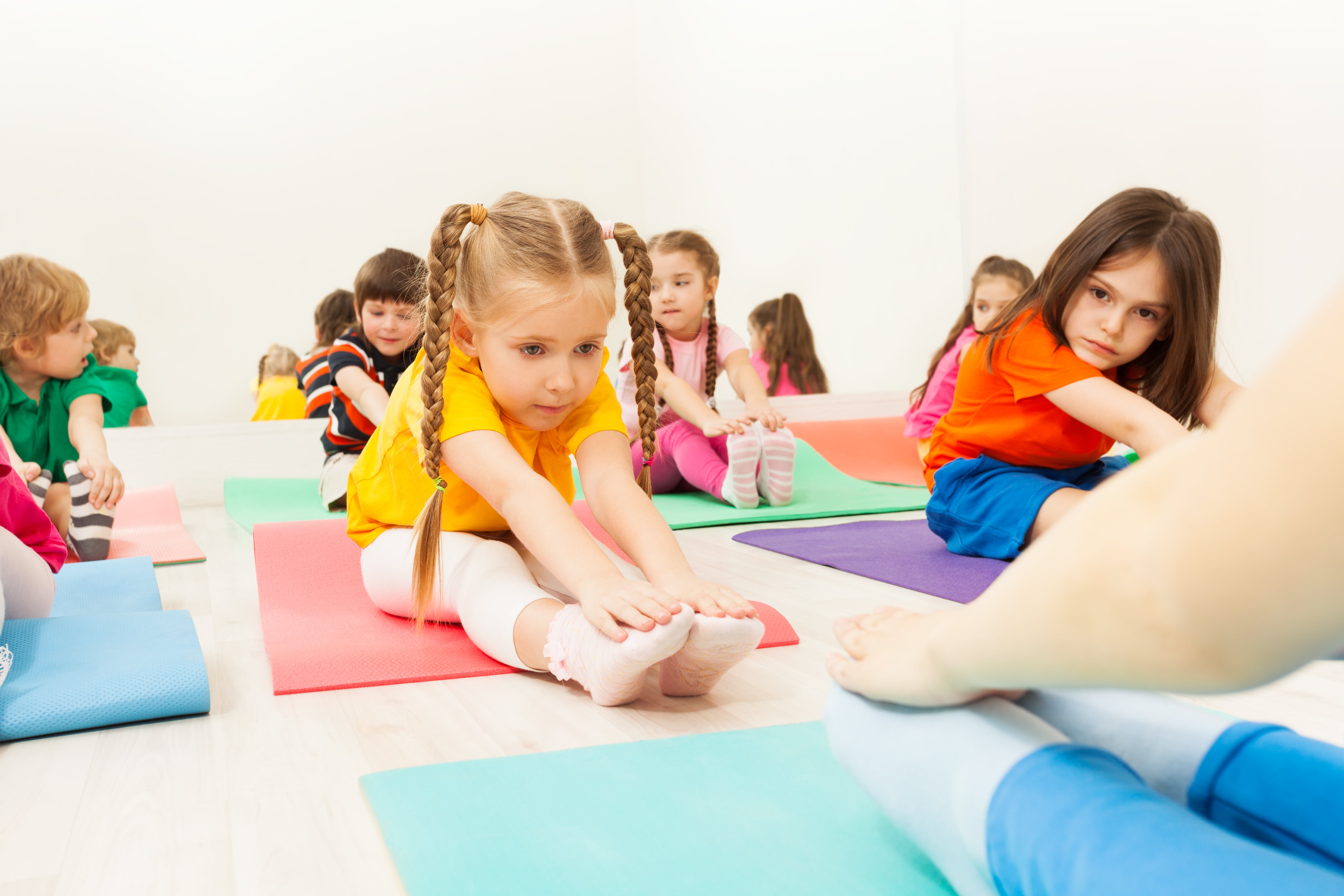 Children on the gym floor doing stretches