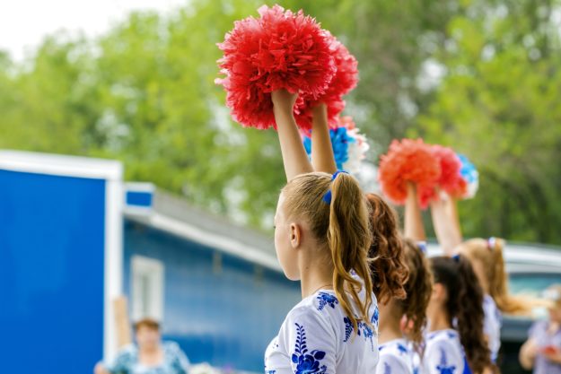 Group of girls holding red pom poms-min Group of girls holding red pom poms