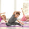 Group of children doing gymnastics exercises on mats