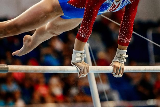 Gymnastics competitor working on uneven bars-2 Gymnastics competitor working on uneven bars