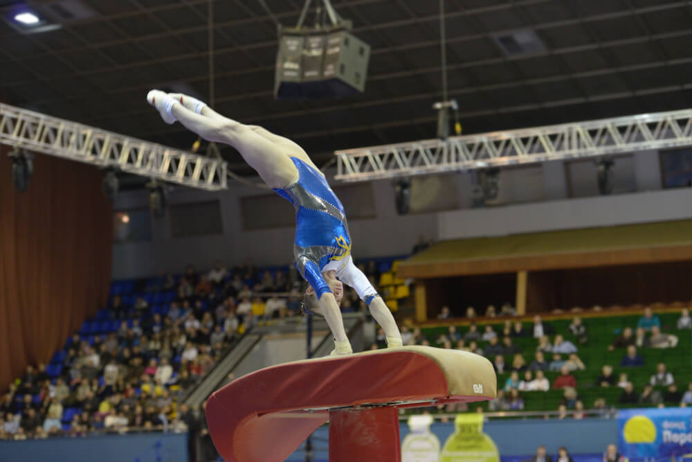 Woman performing stunt on gymnastics vault